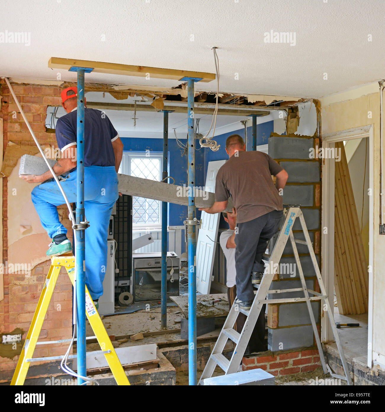 Builders at work install new lintel beam during major extension & alterations to detached house Brentwood Essex England UK see 'More Info' note below Stock Photo