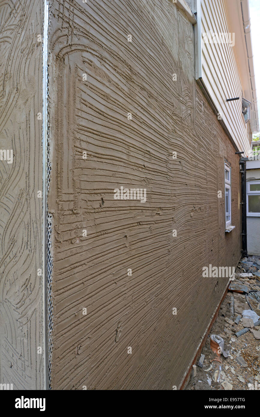 Cement & sand rendering scratch coat on house wall showing corner angle bead Essex England UK see 'More Info' note below Stock Photo