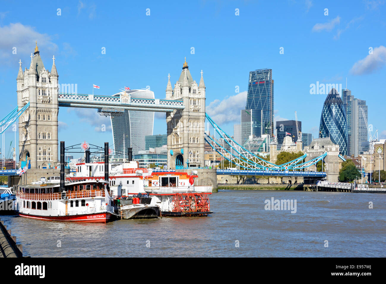 Replica paddle tour boats on the River Thames with Tower Bridge and City London 2014 cityscape skyline beyond Stock Photo