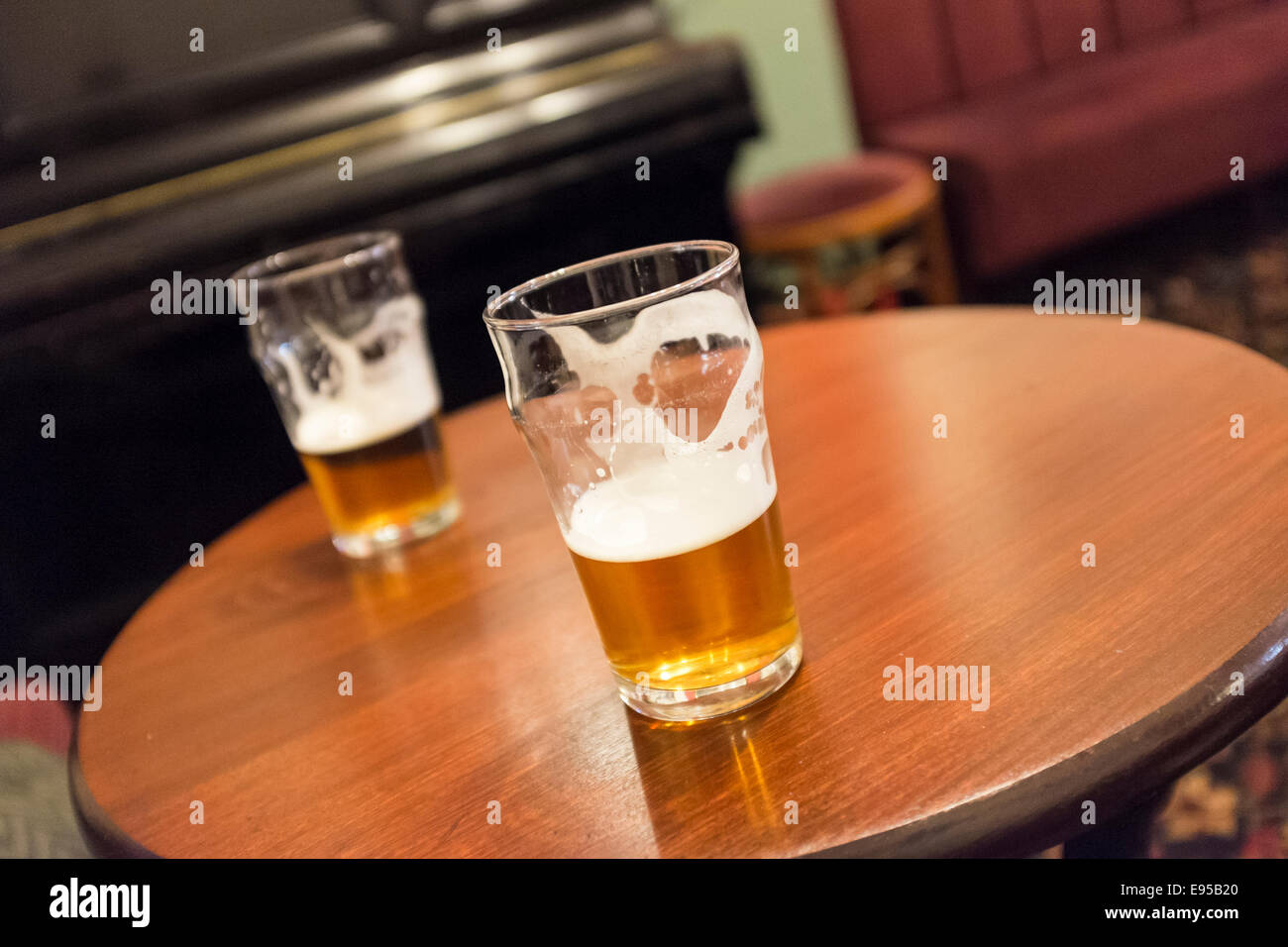 Two beer glasses on a pub table in a traditional british pub Stock