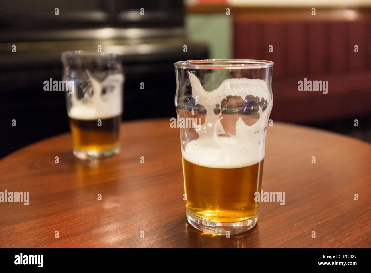 Two beer glasses on a pub table in a traditional british pub Stock