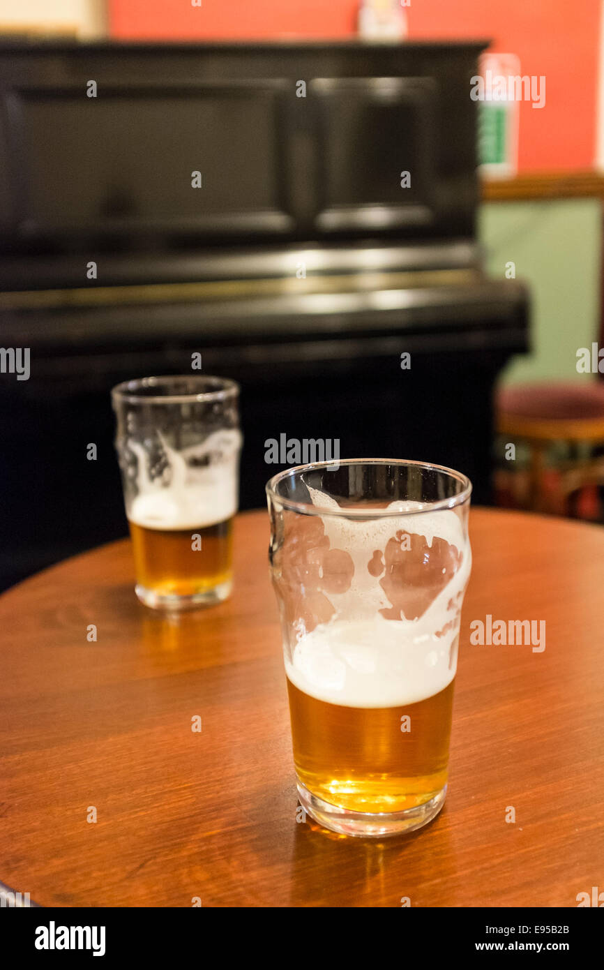 Two beer glasses on a pub table in a traditional british pub Stock ...