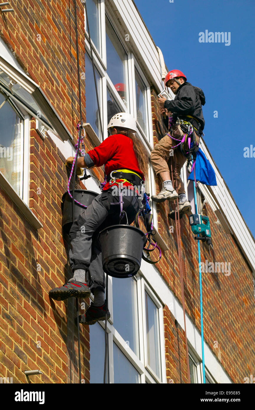Abseil workers pointing brickwork Stock Photo