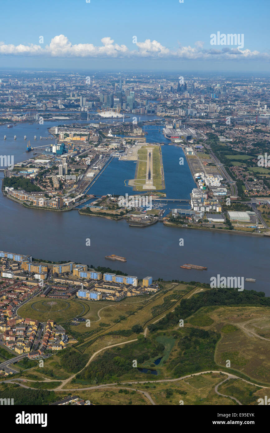An aerial view of London on a clear summer day. London City Airport is visible in the foreground with the city behind. Stock Photo