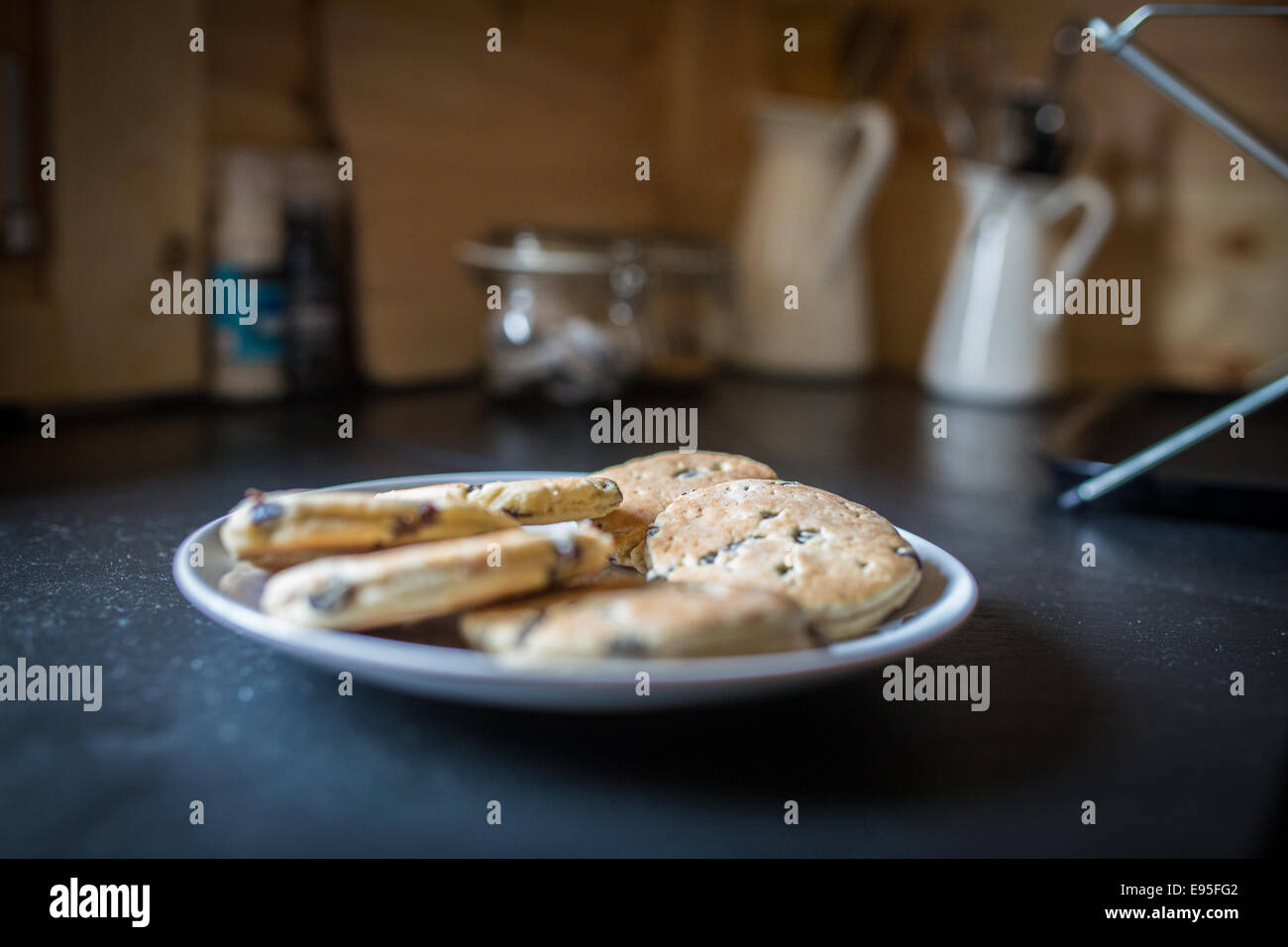 Freshly baked Welsh Cakes on plate on kitchen worktop Stock Photo
