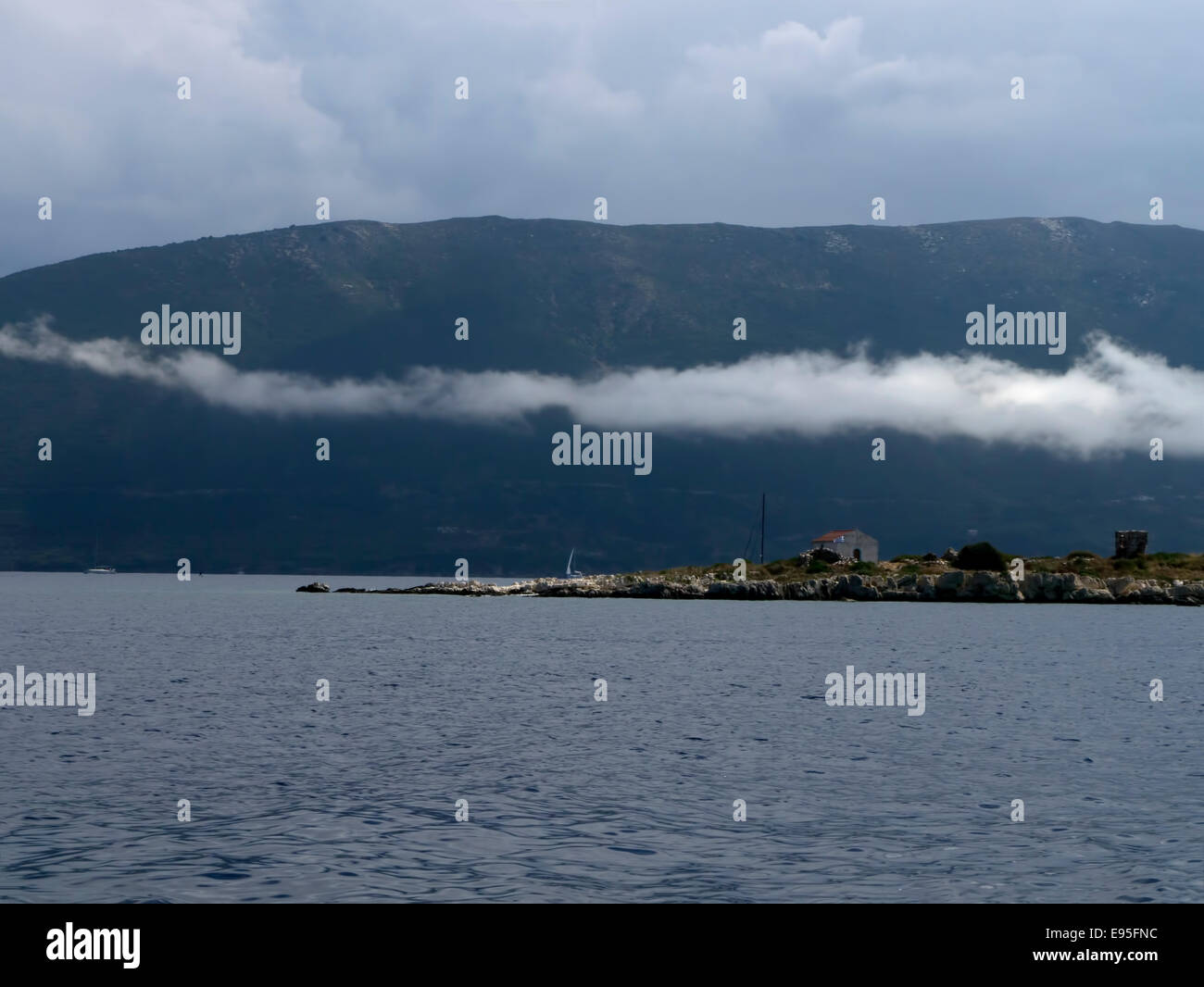 A trail of low lying stratus clouds Kefalonia in Greece Stock Photo