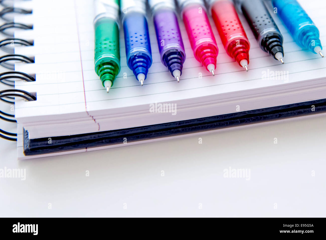 back to school supplies, bright multi colored pens and a spiral ...