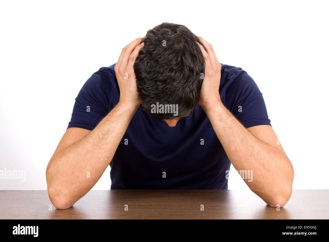 Downcast man holds his head as he suffers from depression and failure. Stock Photo