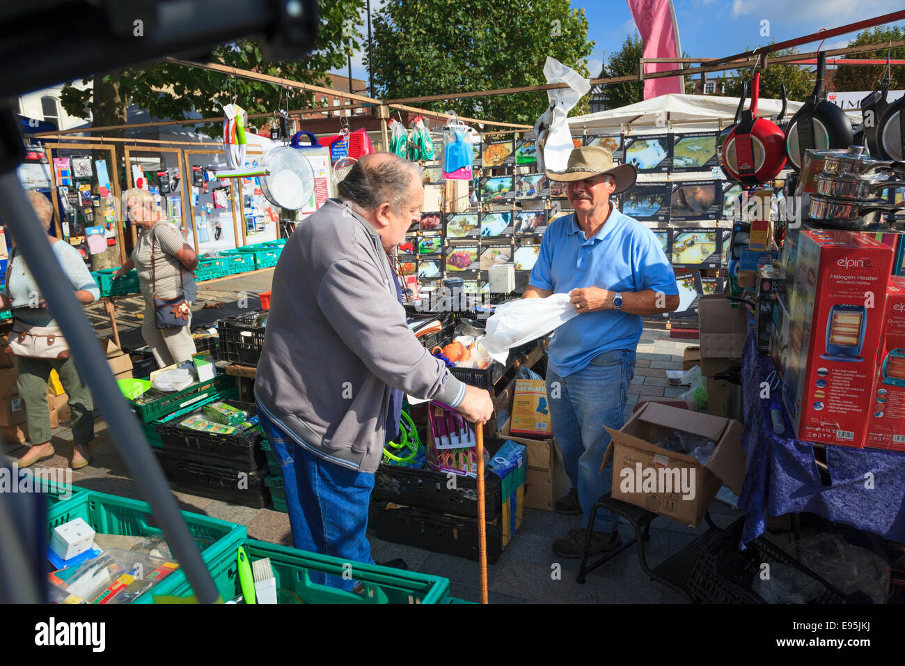 Market trader selling household goods serving a customer Stock Photo - Alamy