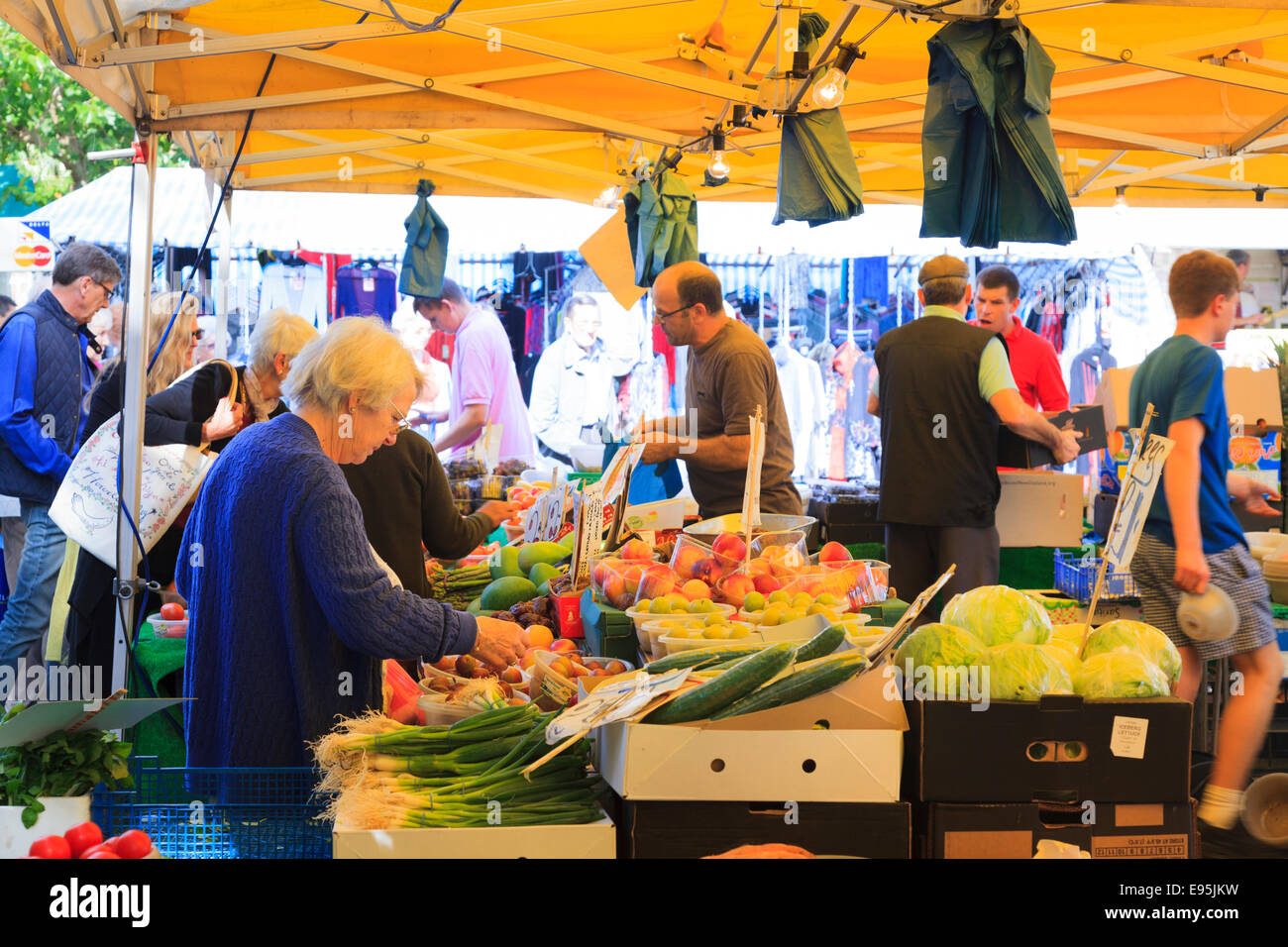 Customers selecting produce at a fruit and veg market stall Stock Photo