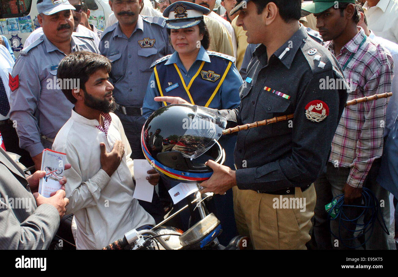 Traffic Police officer distributing helmet among motorcycle riders during “Ride Safely