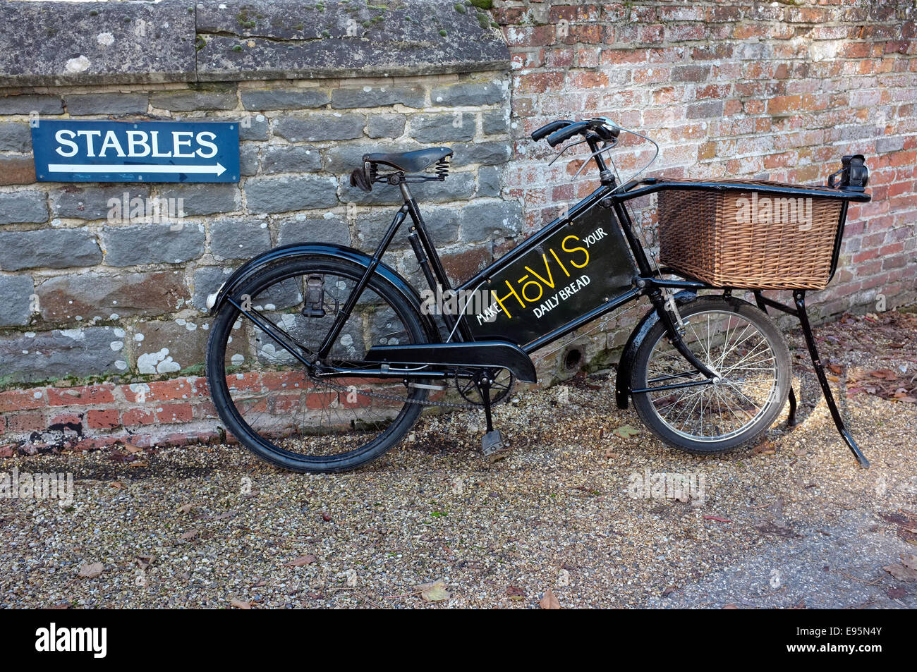 Vintage 1930's bakers (Tradesman's) delivery bicycle with wicker basket and old  sign writing Hovis advertising board. Stock Photo