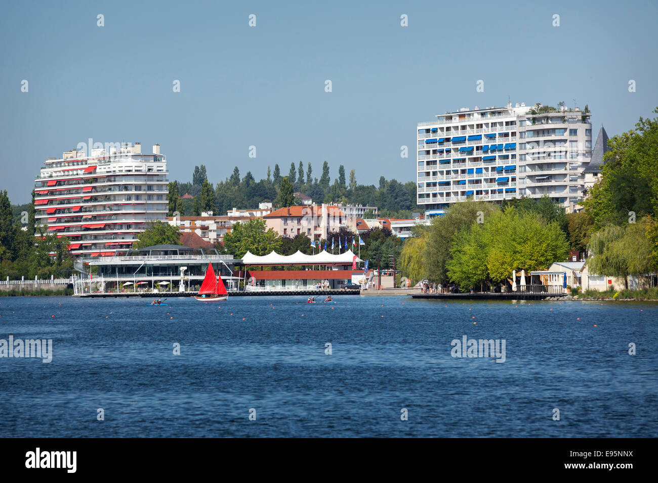 In Summer, a small red sailing boat on the Allier Lake (Vichy). Petit voilier à voiles rouges sur le Lac d'Allier, à Vichy. Stock Photo