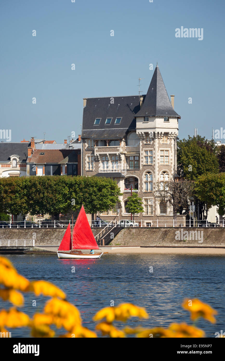 In Summer, a small red sailing boat on the Allier Lake (Vichy). Petit voilier à voiles rouges sur le Lac d'Allier, à Vichy. Stock Photo