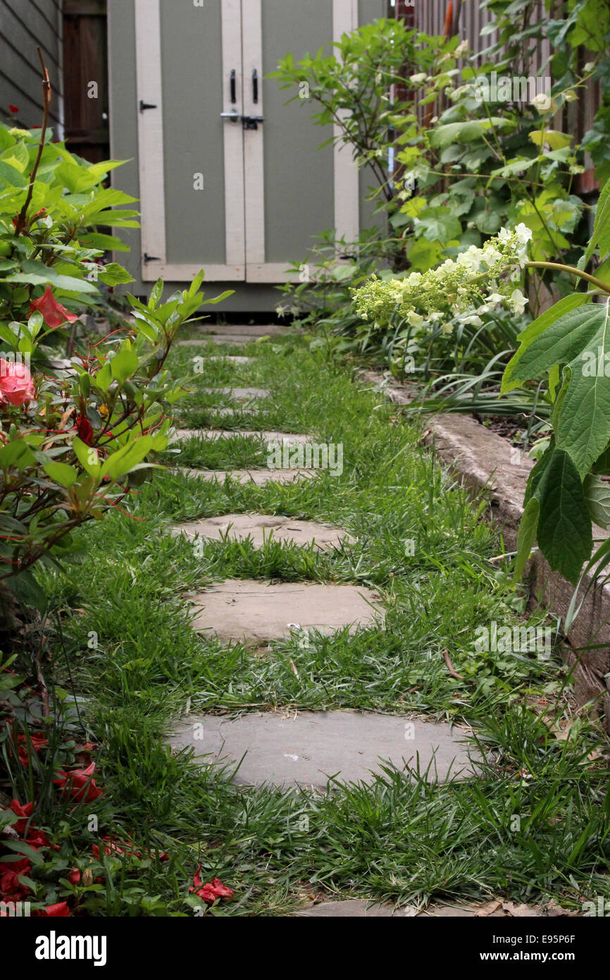 A garden path leading to a quaint shed. Stock Photo