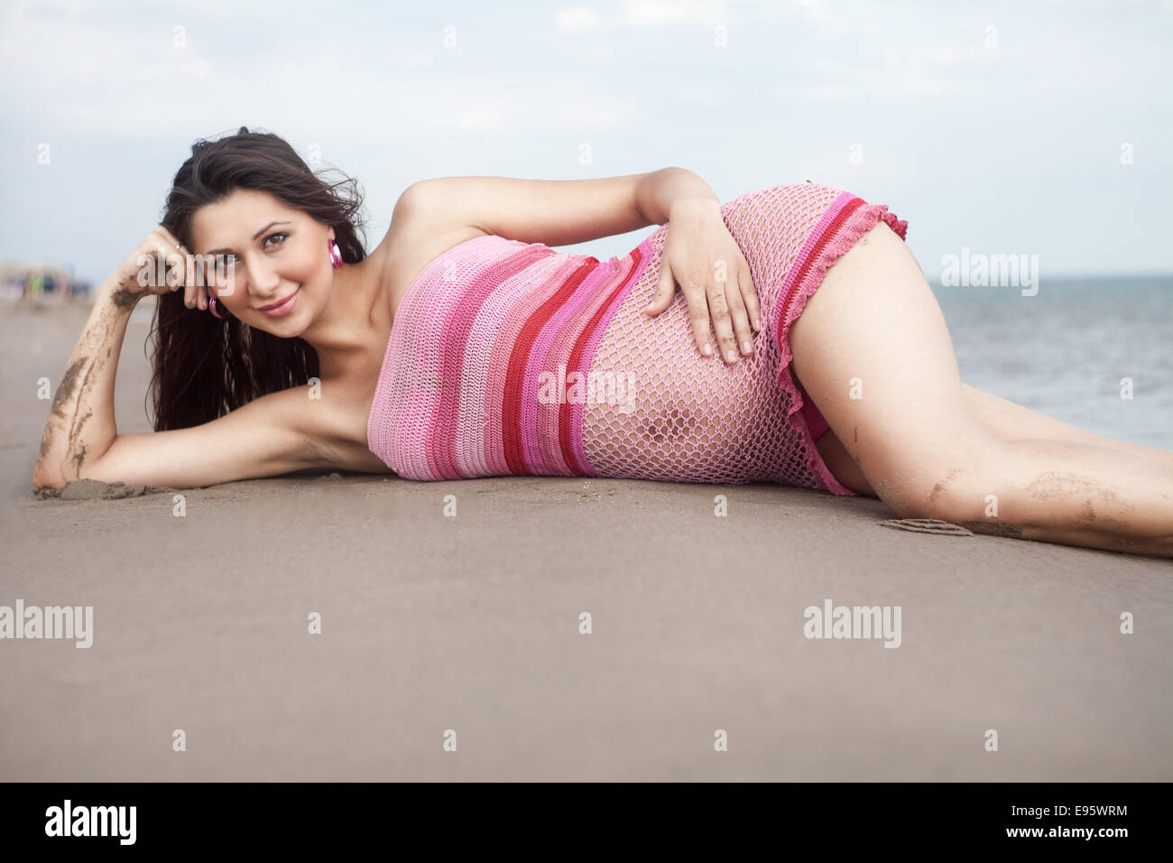 Pregnant woman in white bikini posing on the beach Stock Photo