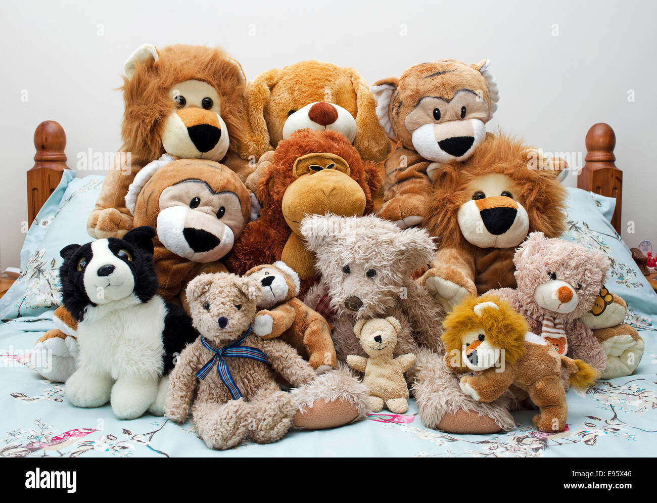 a collection of soft cuddly toys on a bed Stock Photo