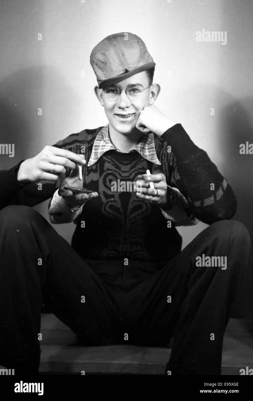 This trick photography image, shot in a studio on April 26, 1948, shows a young man with four hands. It is part of an album titled 'Fort Macleod's Anonymous,' taken in Fort Macleod, Alberta, capturing creative photographic techniques used during that time period. Stock Photo