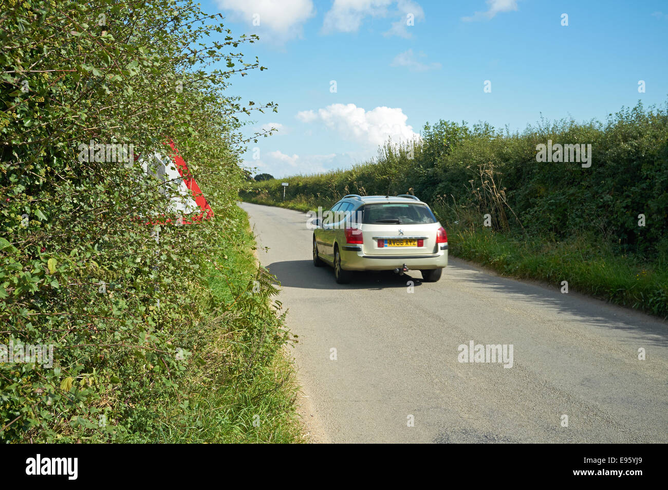 Partly hidden road traffic sign showing side road ahead Stock Photo - Alamy