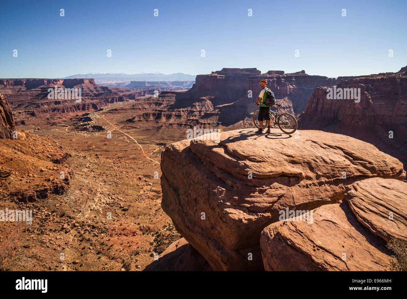Whit Richardson stand with his mountain bike overlooking Shafer Canyon on the White Rim trail, Canyonlands National Park, Moab, Stock Photo
