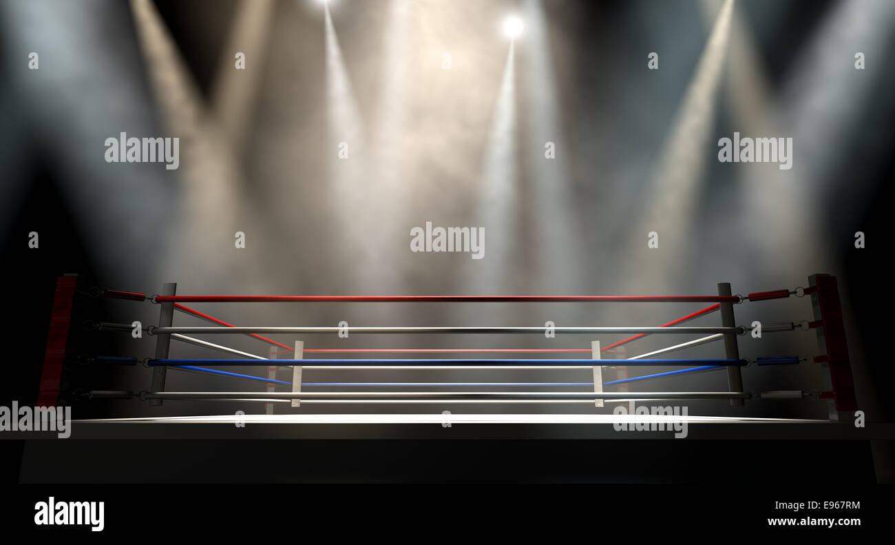 A regular boxing ring surrounded by ropes spotlit by various lights on an isolated dark background Stock Photo