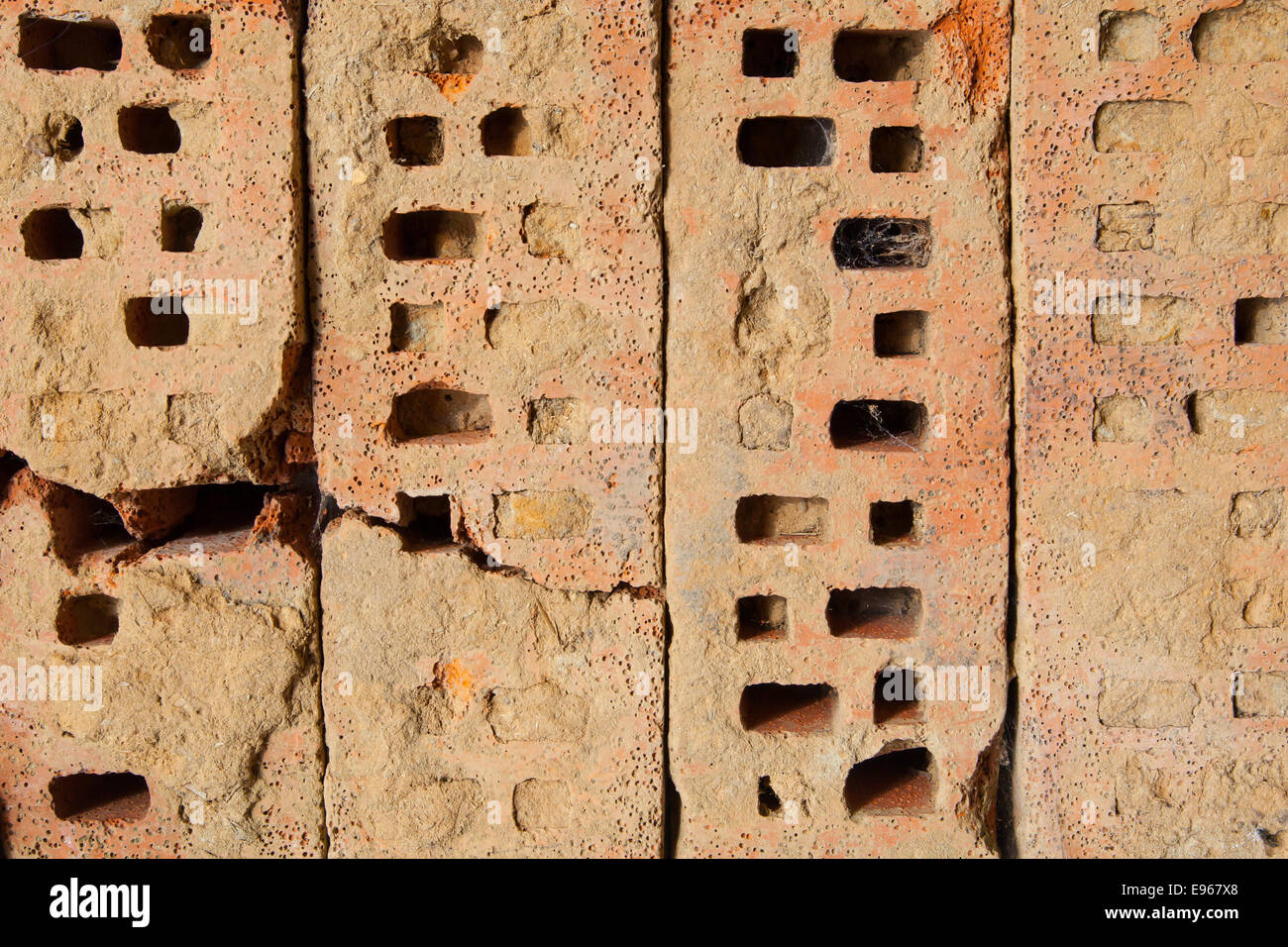 Four old bricks with holes on a row Stock Photo
