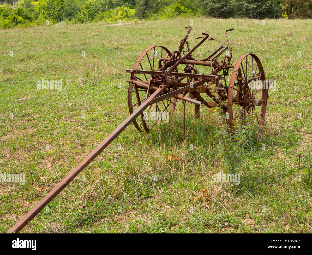 Unused and rusted farm plow in field Stock Photo