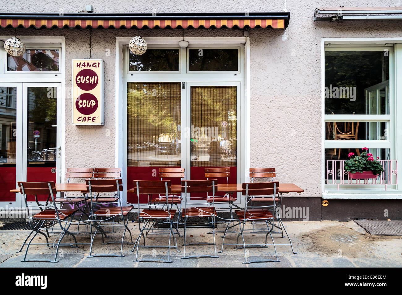 Exterior of Asian restaurant with tables and chairs on pavement on Kastianienallee, Mitte
