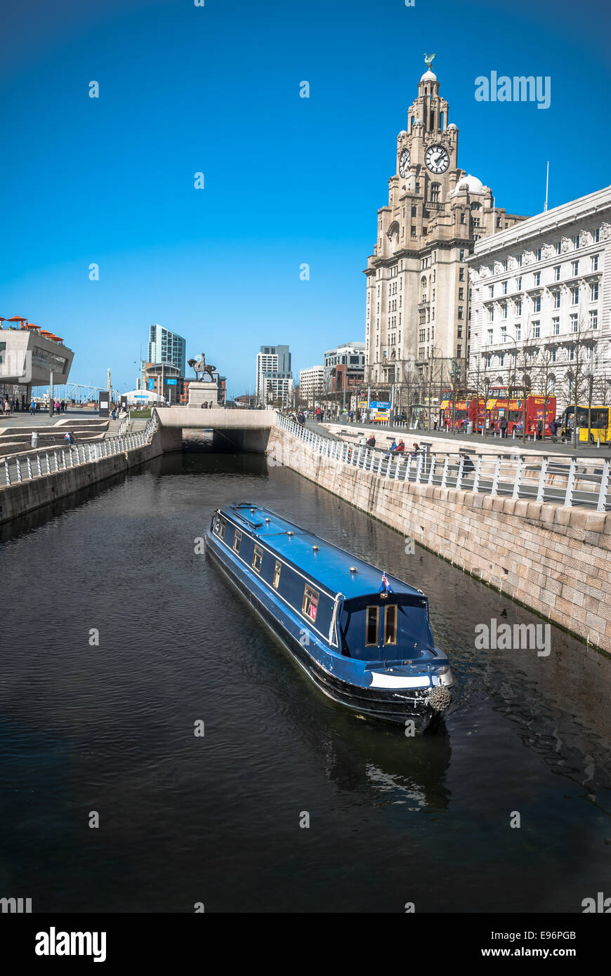 A narrowboat cruising along the Liverpool central canal link at Pier Head with the Liver Building and ferry terminal in the backg Stock Photo