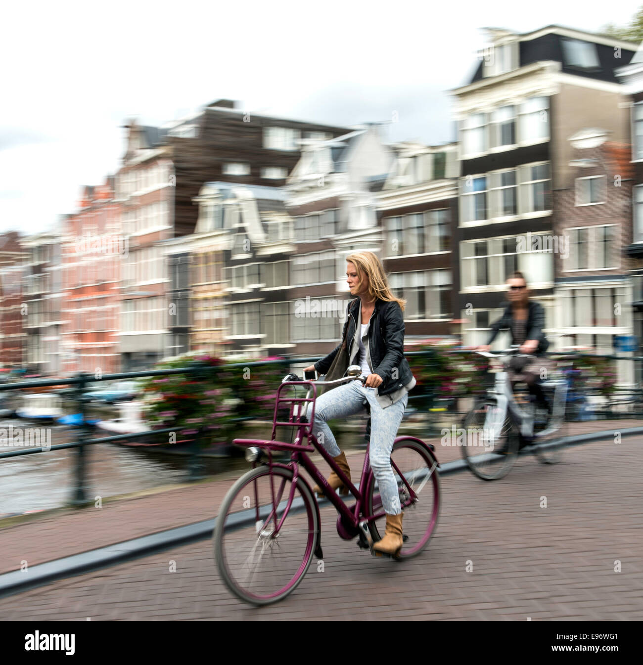 Young woman riding bicycle in Amsterdam Netherlands (Holland) Europe Stock Photo