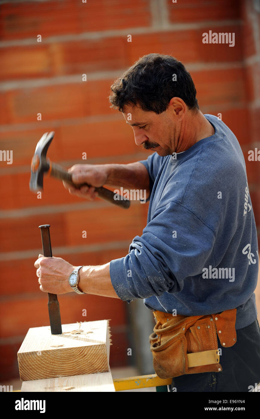 Worker using chisel and hammer on large block of wood Stock Photo - Alamy