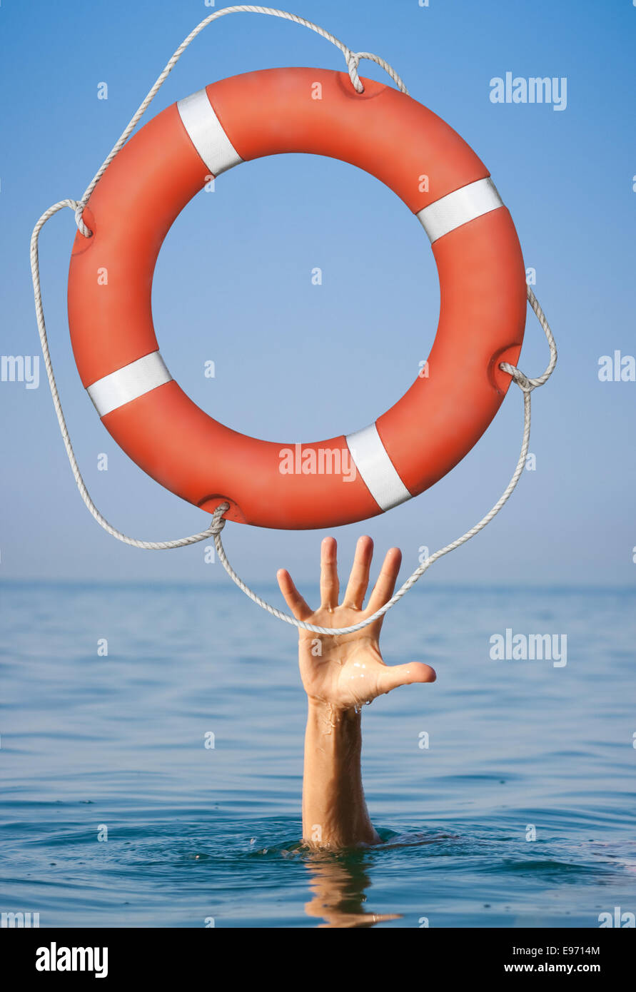 Help concept. Lifebuoy for drowning man's hand in open sea or ocean water. Stock Photo