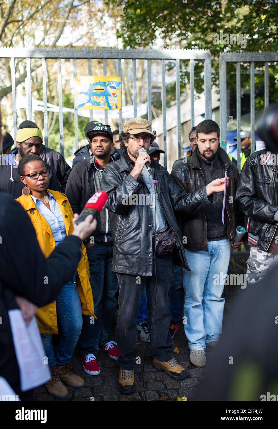 Berlin, Germany. 21st Oct, 2014. Activists and refugees speaking at a press conference in front of the Gerhart Hauptmann School in Berlin, Germany, 21 October 2014. Supporters demand that the district preserve refugee accommodations as well as the construction of a refugee cultural and social center. Credit:  dpa picture alliance/Alamy Live News Stock Photo