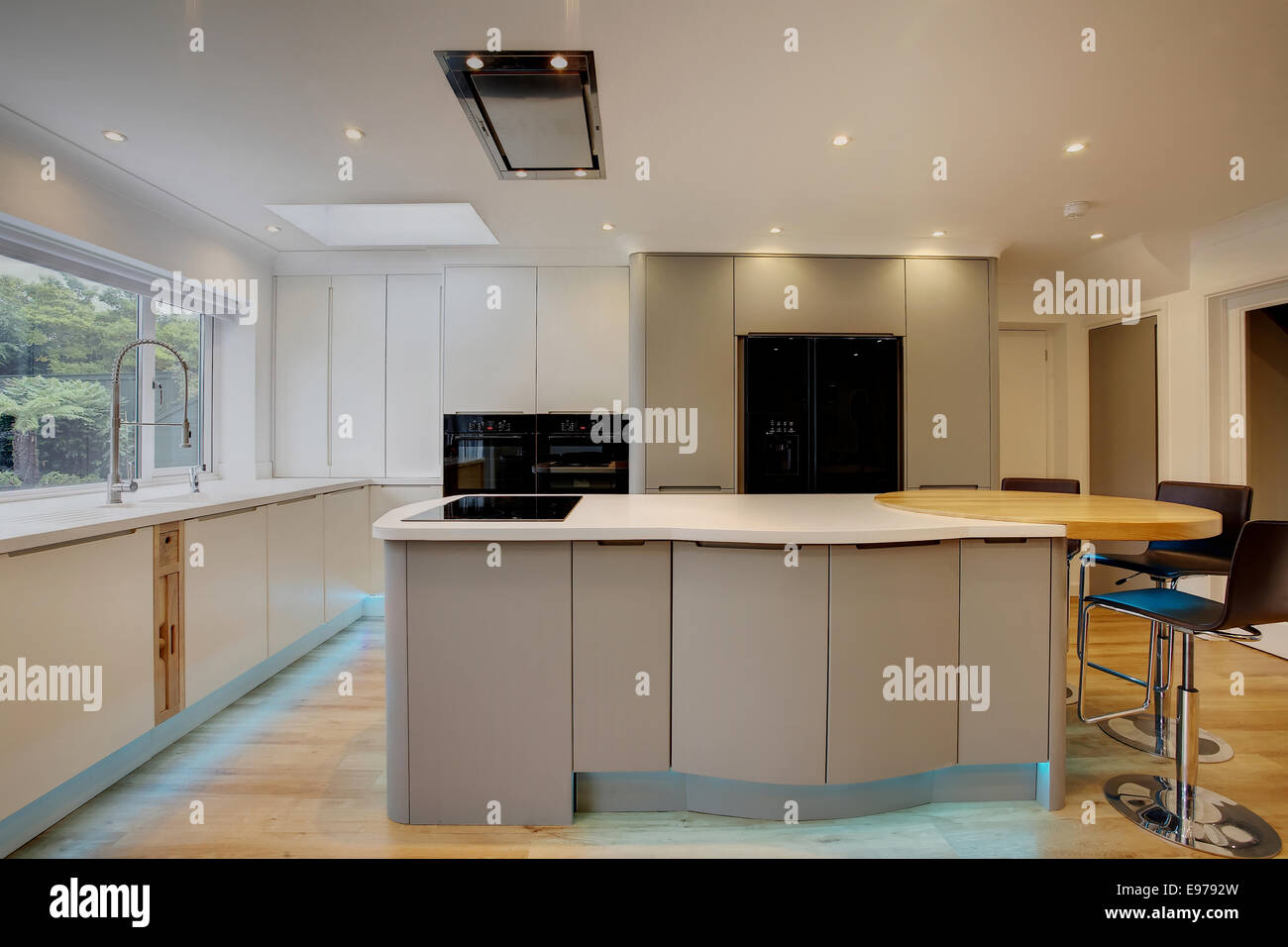 A modern kitchen inside a home in the UK with a breakfast island. Stock Photo