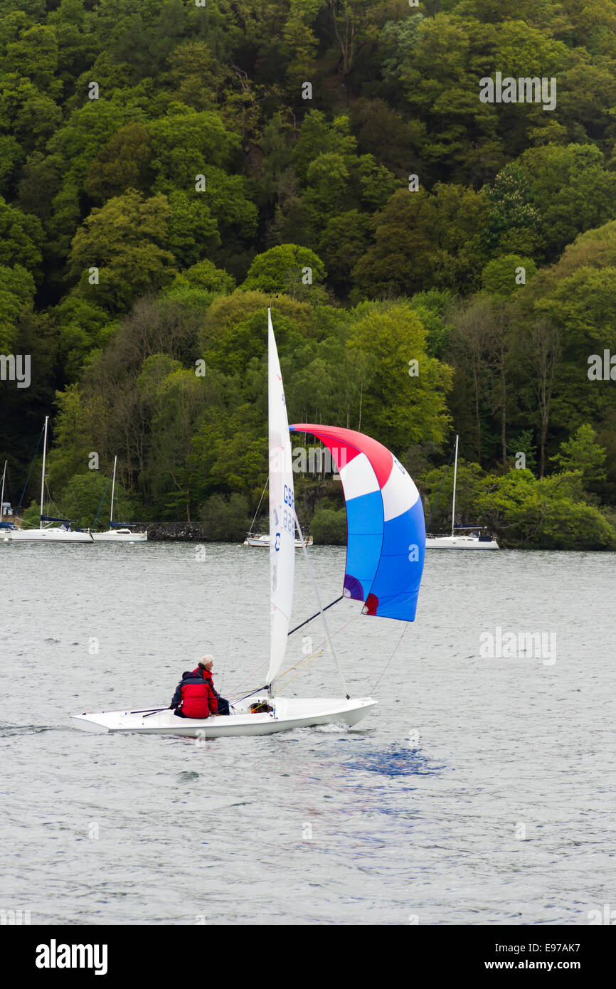Small sailing dinghy with spinnaker sail on Lake Windermere in the English Lake District Stock Photo