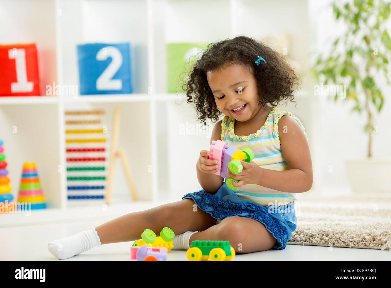 Kid girl playing toys at kindergarten room Stock Photo