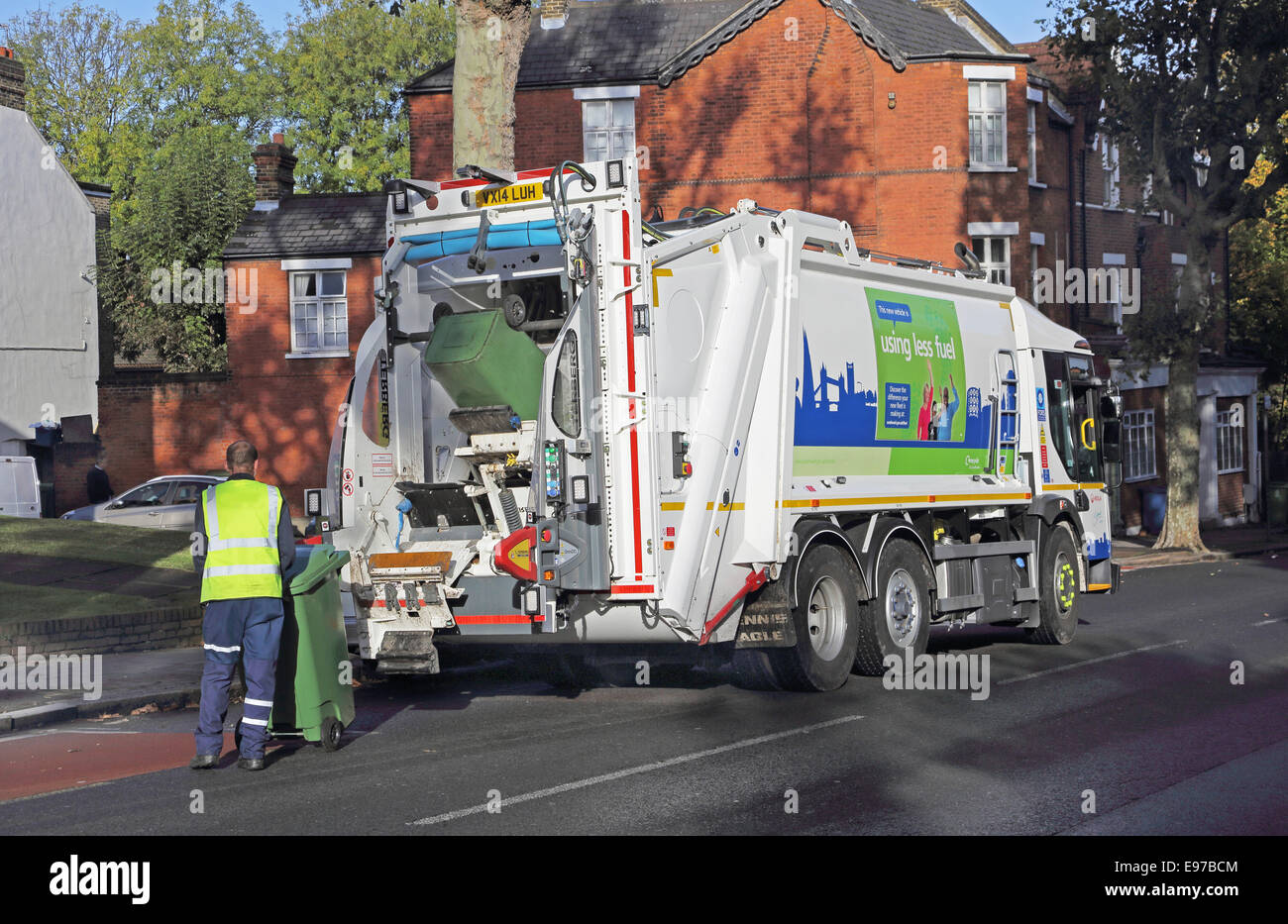 A contractor empties a domestic refuse wheely bin into a modern refuse collection vehicle Stock Photo