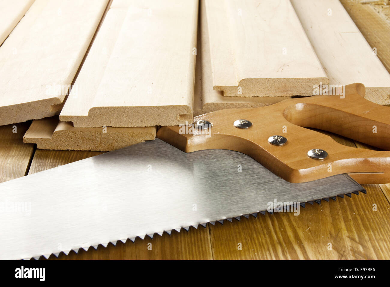 Carpenter's saw is on a woode planks Stock Photo