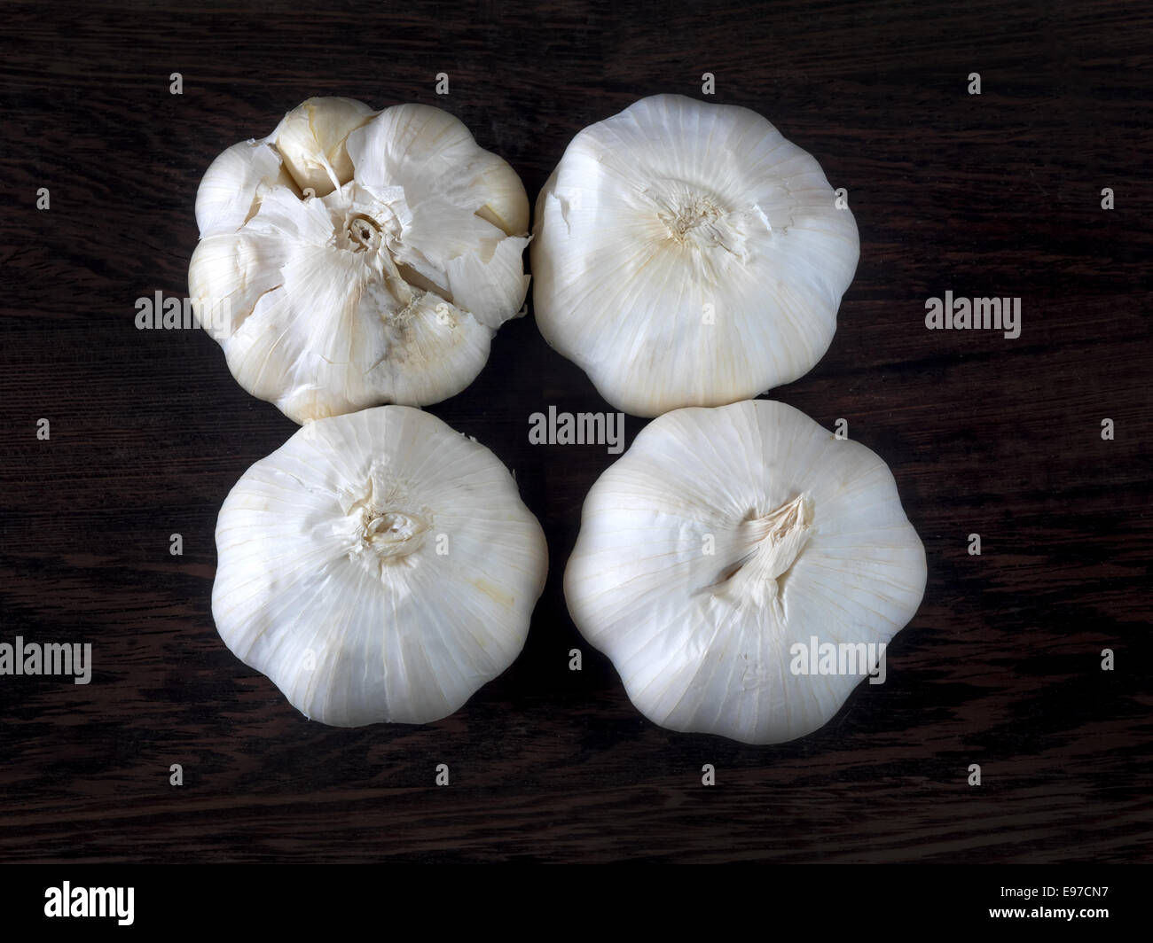 Four garlic bulbs on a dark background Stock Photo