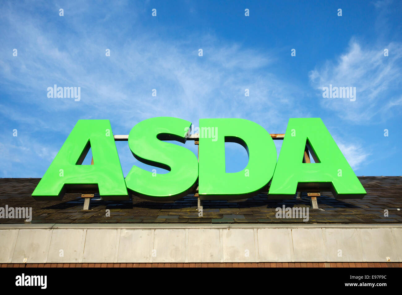 The Asda sign above a supermarket, against a blue sky, UK Stock Photo