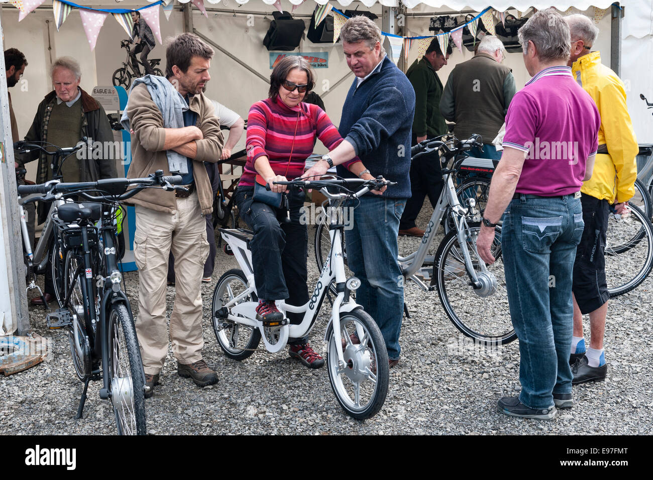 Presteigne, Powys, UK. Interested visitors trying out electric bikes at a trade show Stock Photo