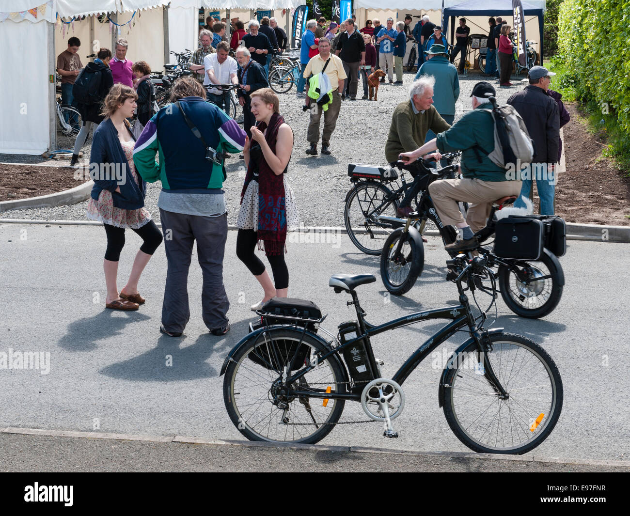 Presteigne, Powys, UK. Interested visitors trying out electric bikes at a trade show Stock Photo