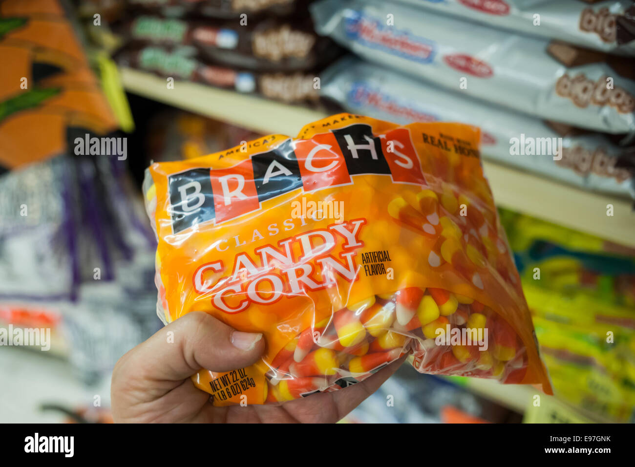 A shopper chooses a bag of Brach's Halloween candy corn in a