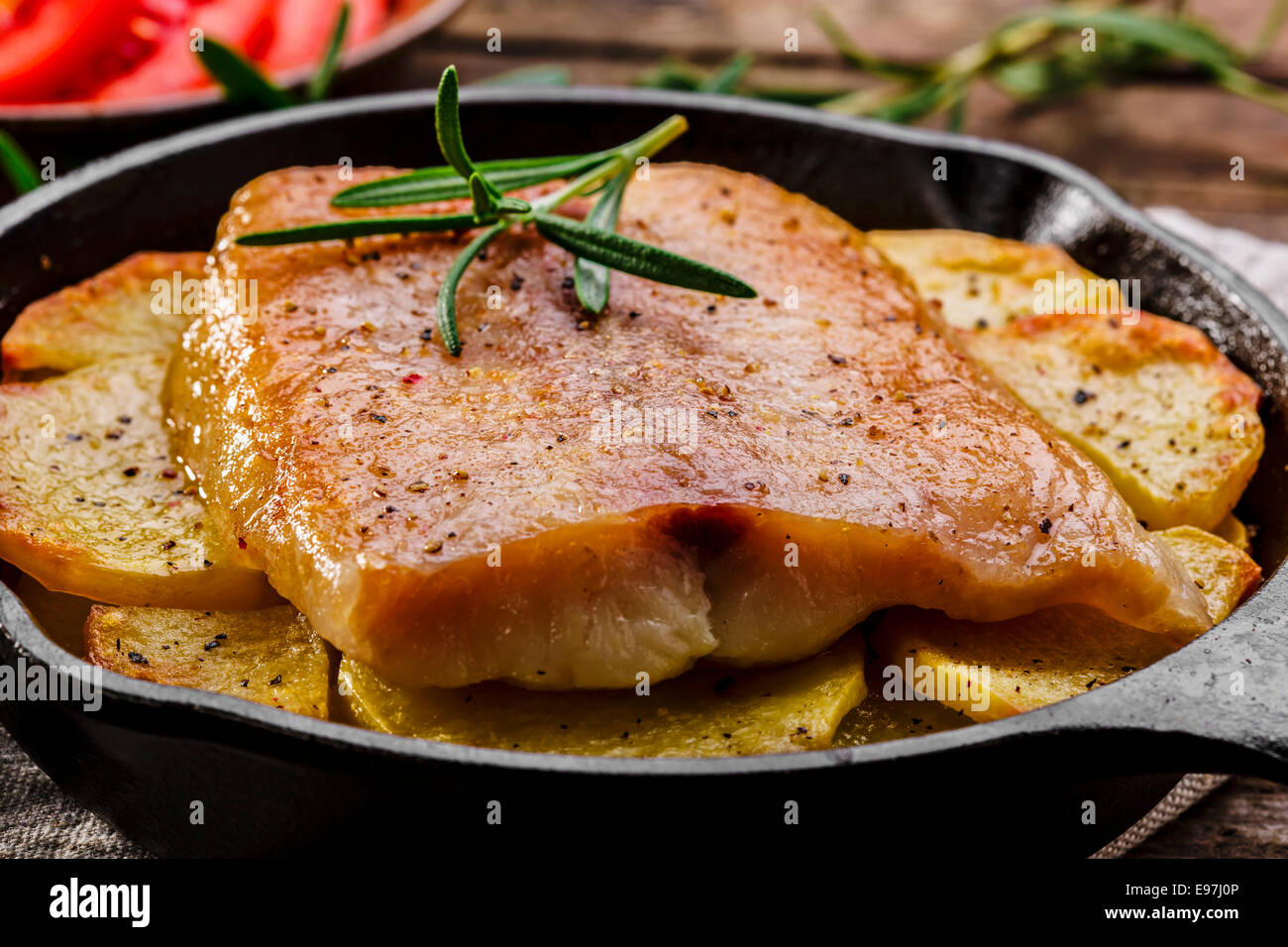 Baked fish fillets with potatoes in a frying pan Stock Photo