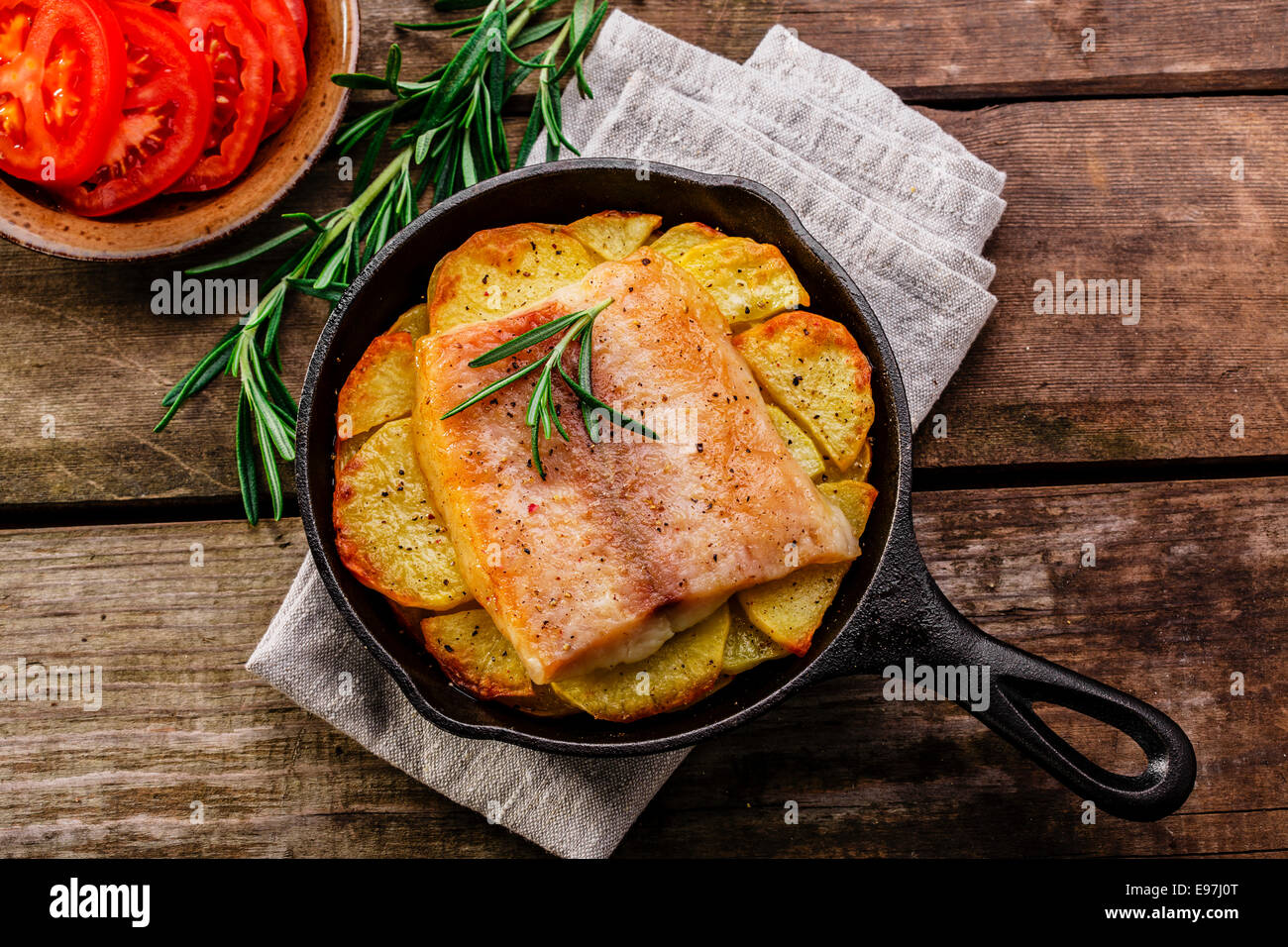 Baked fish fillets with potatoes in a frying pan Stock Photo