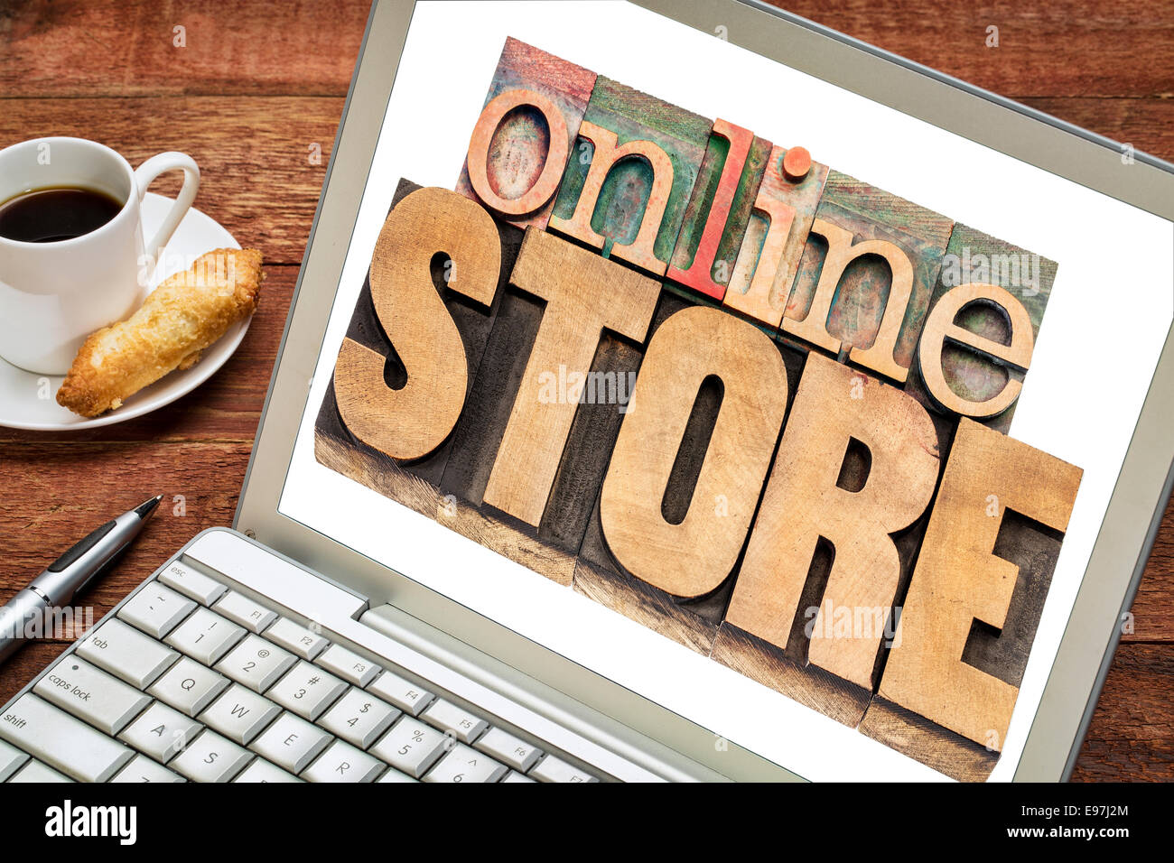 online store - text in letterpress wood type on a laptop screen, cup of coffee Stock Photo