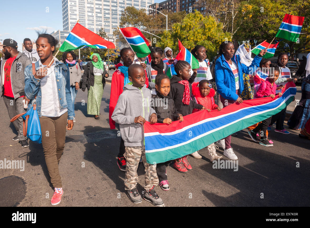 Participants carrying flags from Gambia march in the African Day Parade in Harlem in New York