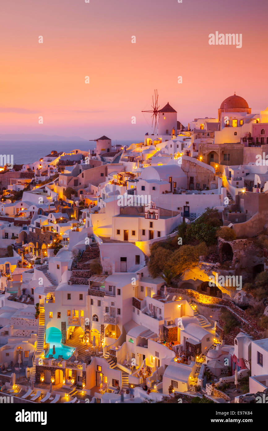 Windmill and traditional white houses at sunset  in the village of Oia, Santorini, Thira, Cyclades Islands, Greek Islands, Greece, EU, Europe Stock Photo