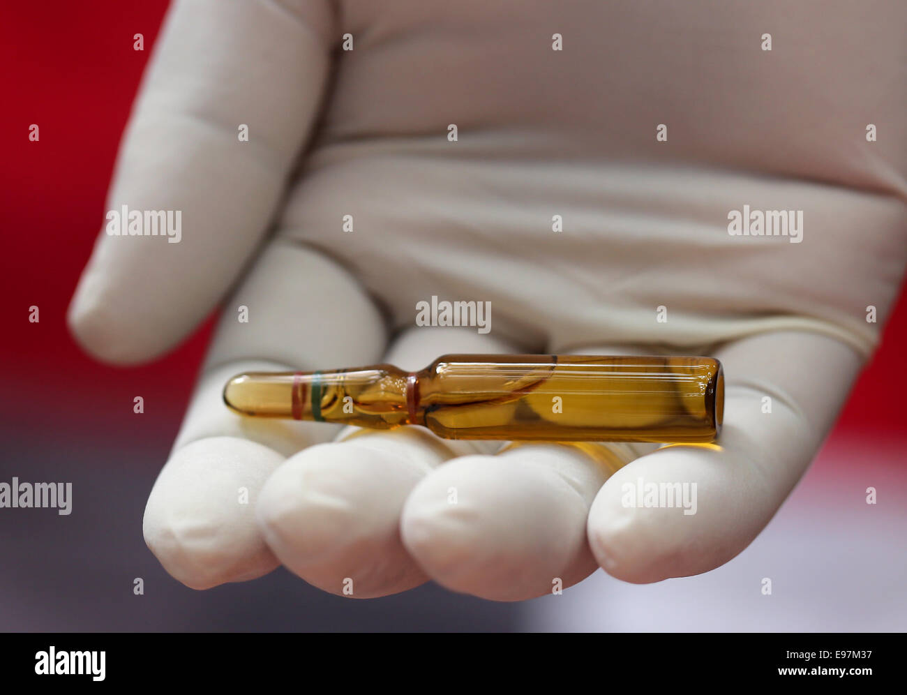 Close up of an ampoule holding by hand with gloves Stock Photo