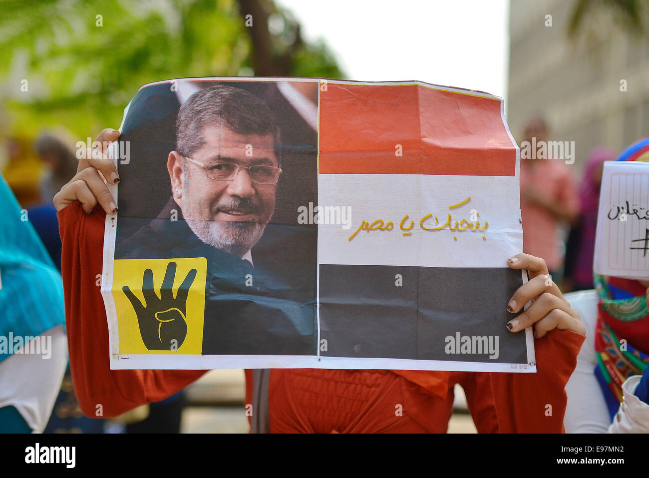 Cairo, Egypt. 21st Oct, 2014. An Egyptian student who support Muslim Brotherhood, holds the picture of ousted president Mohammed Morsi during a demonstration against military rule and to demand for release their fellows, at Cairo University, in Cairo, October 21, 2014. Anti-Coup students have launched a week-long 'breaking the siege' campaign in protest against security forces tight grip on university campuses across Egypt Credit:  Amr Sayed/APA Images/ZUMA Wire/Alamy Live News Stock Photo